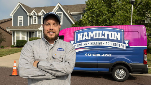 Smiling Hamilton technician standing next to company van to provide air conditioning service in Kansas City.
