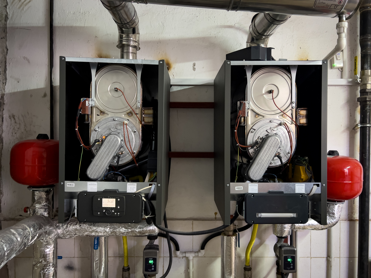 Close-up of two industrial-grade furnace units with visible components such as fans, pipes, and controls.